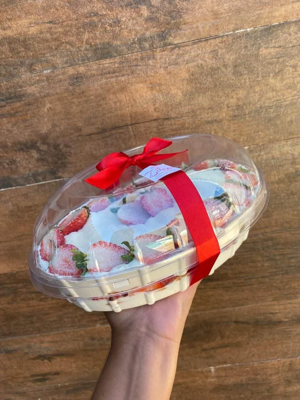 Sobremesa especial de morango em embalagem oval com laço vermelho